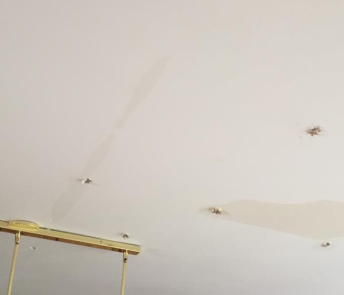 White ceiling with holes and discoloration.