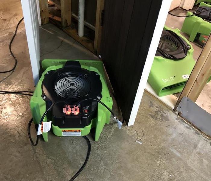 Green air movers on concrete flooring.