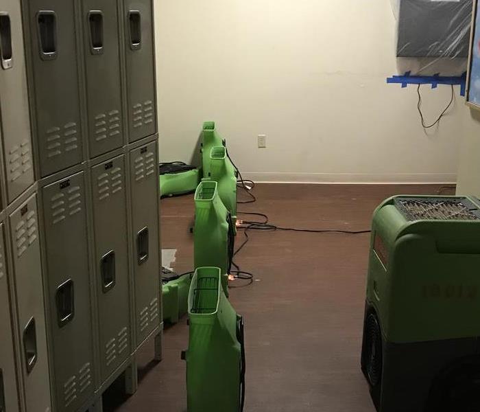 locker room with green air movers on the floor. 