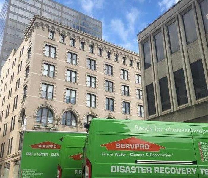SERVPRO van in front of a tall building outside. 