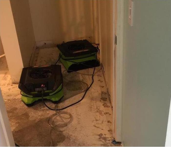 Two air movers drying the hallway of a home